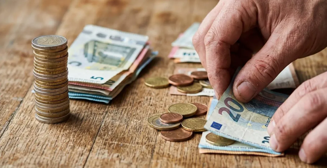 Mains manipulant deux ensembles de pièces et billets représentant différents calculs fiscaux