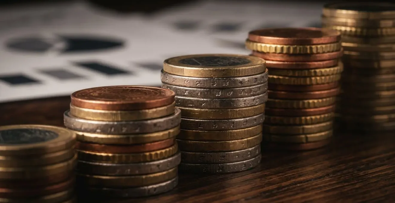 Vue macro sur des pièces de monnaie empilées avec reflet de documents fiscaux